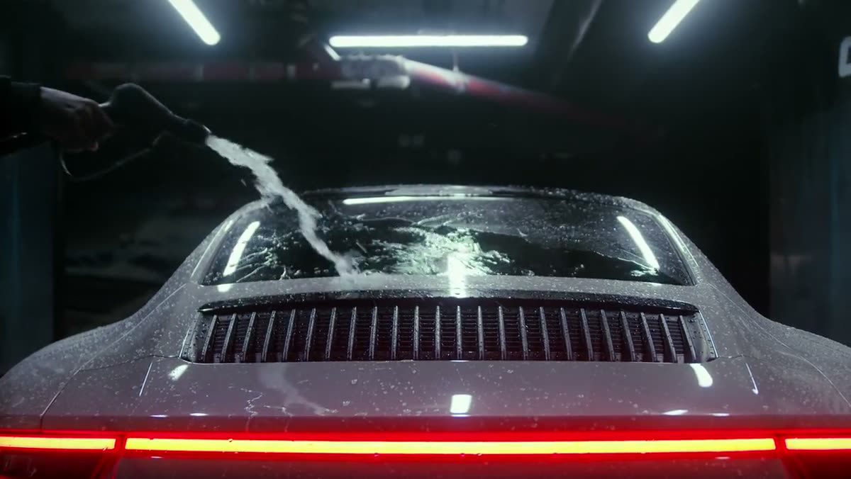 Rinsing a sports car under studio lights